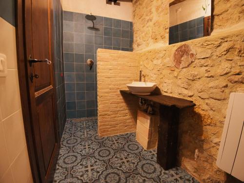 a bathroom with a sink and a stone wall at B&B Manca1Fiorino in Spoleto