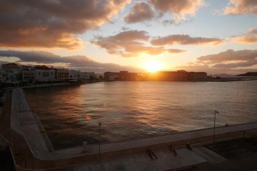 a sunset over a body of water with buildings at KALLINO Island Suites in Ermoupoli