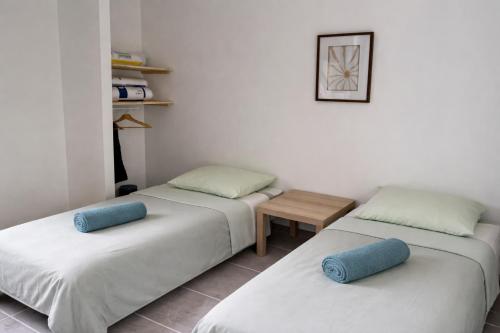 a room with two beds with pillows and a table at Gite du Lac T4 in Vieux-Boucau-les-Bains