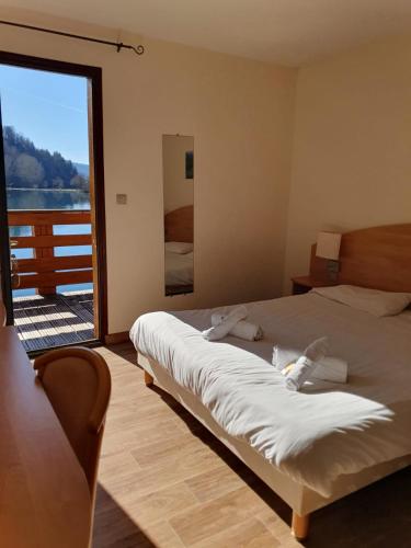 a bedroom with a bed with a view of the water at Lac des Graves in Lascelle