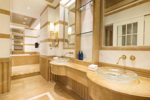 a bathroom with two sinks and a large mirror at Radisson Blu Hotel Shanghai New World in Shanghai