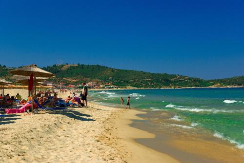 a group of people sitting on a beach at House Blerina - Sarti Chalkidiki in Sarti