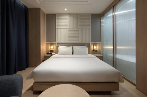 a bedroom with a large white bed in a room at H-Avenue Hotel Yeongildae in Pohang