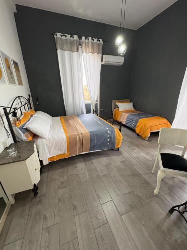 a bedroom with two beds and a desk and a chair at DAREB HOME vista mare in Agrigento