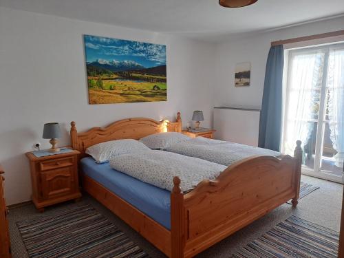 a bedroom with a large wooden bed and a window at Bauernhaus Jocher in Krün