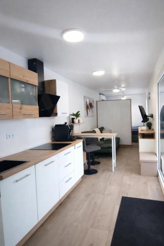 ein Büro mit einer weißen Küche und einem Schreibtisch in der Unterkunft Auszeitbox in Schärding