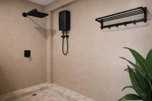 a bathroom with a shower with a speaker on the wall at Sleepy Gypsea Villa Siargao Swell in Catagnan