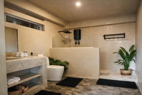 a bathroom with a toilet and a sink at Sleepy Gypsea Villa Siargao Swell in Catagnan