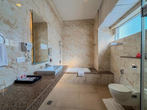 a bathroom with a sink and a toilet and a tub at Spree Resort At Century Wintersun in Dod Ballāpur