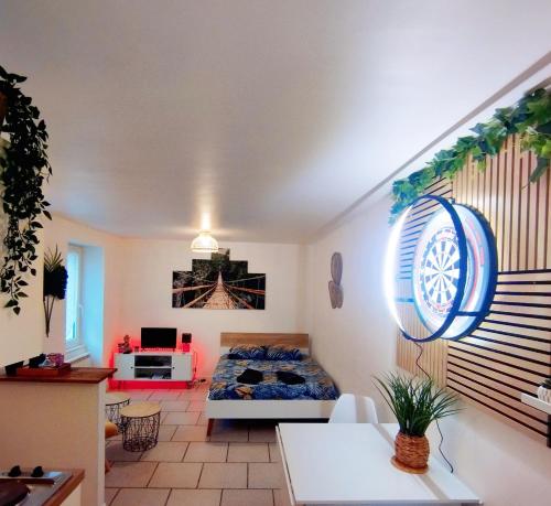 a living room with a bed in a room at studio cosy & fun face aux château fléchettes in Gaillon