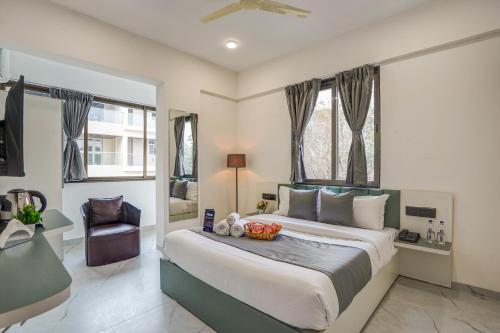 a bedroom with a large bed and a chair at Hotel Zenora in Méribel Village