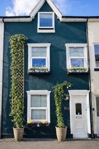 a blue house with white windows and plants on it at Bh2Beach House,4mins to the beach, centrally located, group stays in Bournemouth