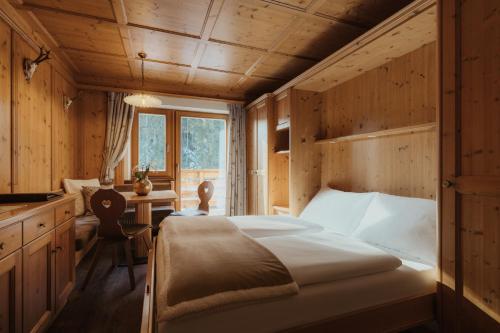 a bedroom with a bed in a wooden room at Residence Ciasa Vedla in Badia