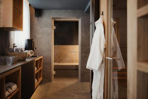 a bathroom with a white robe hanging on a door at Residence Ciasa Vedla in Badia