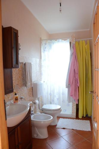 a bathroom with a sink and a toilet and a window at Holiday Homes in Campofelice di Roccella