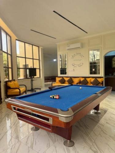 a pool table in a living room with at Al REEM Farm house khorfacan in Sabkhah