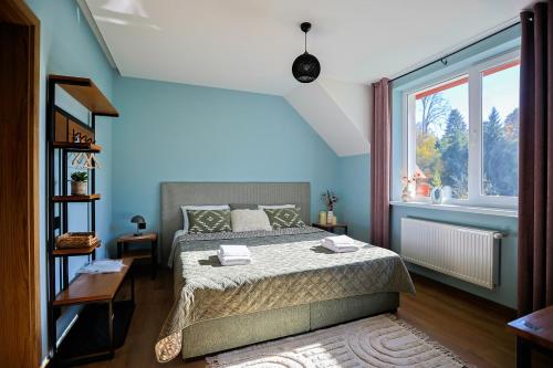 a bedroom with a bed and a large window at AINO Hotel in Pilipets