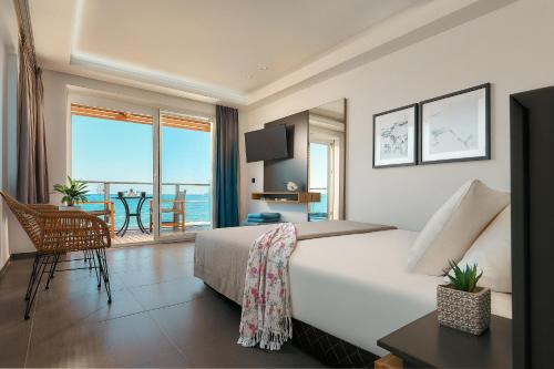 a bedroom with a bed and a view of the ocean at Enorme Infinity Beach ex Infinity Blue in Hersonissos