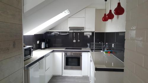 a kitchen with white cabinets and a stove top oven at City Central Promenade in Bad Homburg vor der Höhe