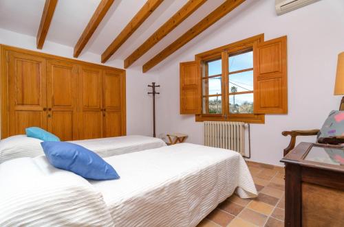 a bedroom with two beds and a window at Sort Nova in Montuiri