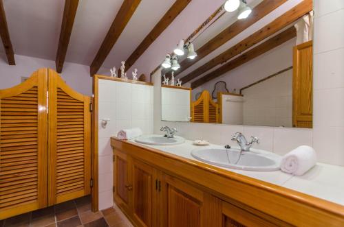a bathroom with two sinks and a large mirror at Sort Nova in Montuiri