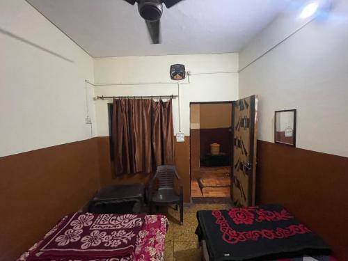 a room with two beds and a chair in it at Shivangi hotel in Bareilly