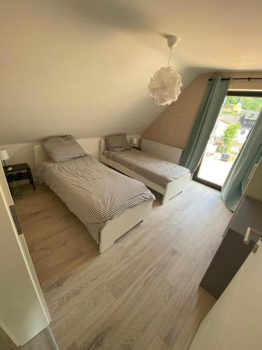 a bedroom with two beds and a window at Relaxen am Waldesrand Fewo 2 in Ahrbrück
