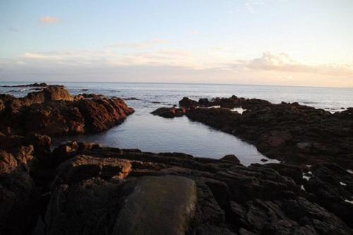 a large body of water on a rocky beach at Casa do Cruzeiro in Lagoa