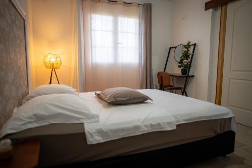 a bedroom with a bed with two pillows and a window at Le Cocon de Bagatelle in Sainte-Suzanne