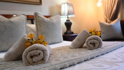 a hotel room with towels and flowers on a bed at Lamor Guest House in Middelburg