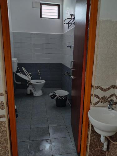 a bathroom with a toilet and a sink at R R Paradaise in Pūtalapattu