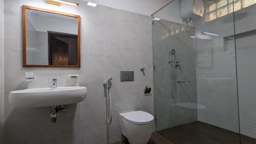 a bathroom with a shower and a toilet and a sink at The Ocean Breeze Villa in Tangalle