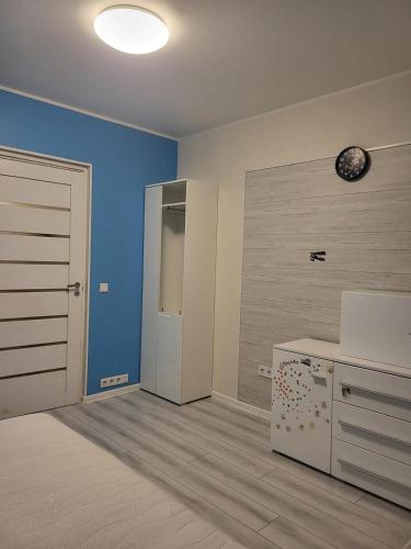 a room with a kitchen with blue walls and a door at A 3-bedroom apartment on the second floor in Tallinn