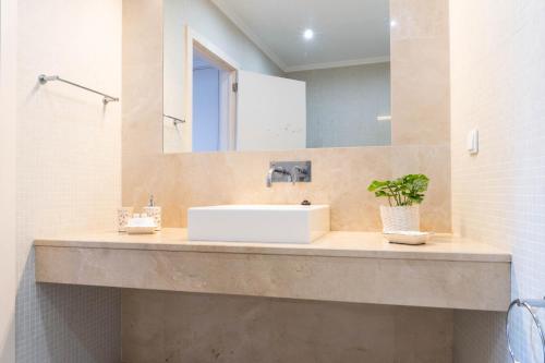 a bathroom with a sink and a mirror at Casa da Arvore Chale by Green Vacations in Calhetas