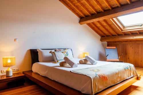 a bedroom with a large bed with two lamps at Casa da Arvore Chale by Green Vacations in Calhetas