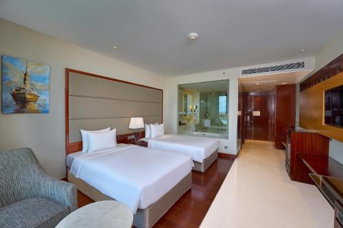 a hotel room with two beds and a couch at Crowne Plaza Kochi by IHG in Cochin