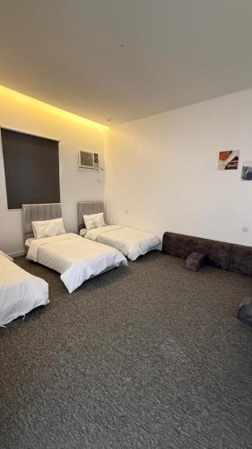 three beds are lined up in a room at شاليه غيوم الفندقية in Taif