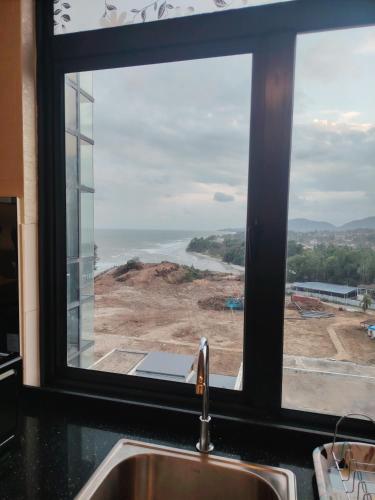 a window view of the ocean from a kitchen sink at Timurbay Seafront By Moonlight in Kuantan