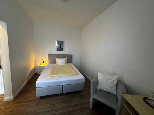 a small bedroom with a bed and a chair at Hotel Zur schönen Aussicht in Grömitz