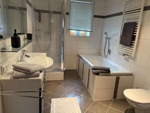 a bathroom with a tub and a sink and a toilet at Ferienwohnung Eichhorner in Außervillgraten