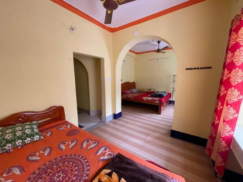 a room with a bed and a living room with a room at Narasimha Dev Guest House in mayapur