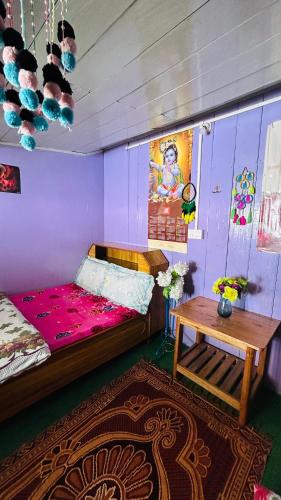 a room with a bed and a table in it at NV Anjali Homestay in Sukhia Pokhari