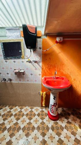 a bathroom with a red sink in a room at NV Anjali Homestay in Sukhia Pokhari