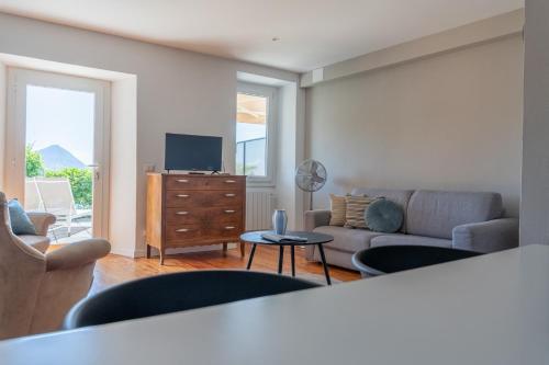a living room with a couch and a tv at Regina e Oriente - La casa del Moro in Baveno