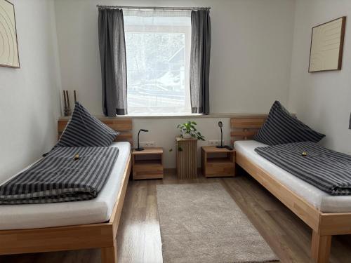 two beds in a room with a window at Ferienwohnung Eichhorner in Außervillgraten