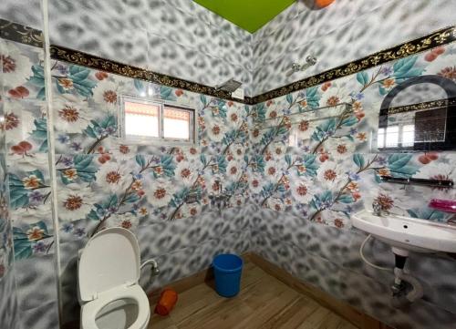 a bathroom with a toilet and a sink at Narasimha Dev Guest House in mayapur