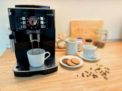 a coffee maker is making cups of coffee on a table at Casa Carlini in Getxo