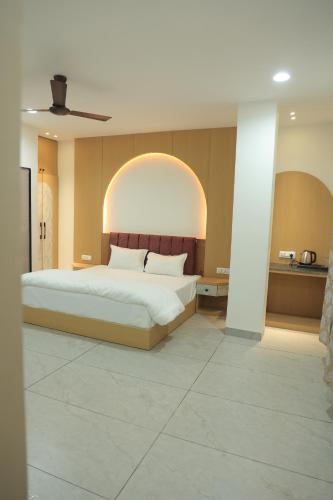 a bedroom with a large bed with an arch above it at Hotel Shiv Om in Ujjain