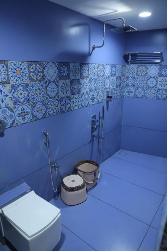 a blue bathroom with a toilet and a sink at Hotel Shiv Om in Ujjain