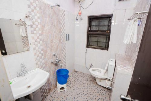 a bathroom with a toilet and a sink at Tulips Resorts - Elkhill in Ooty